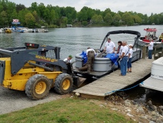 A skid steer loader operated by Take Pride in SML committee member Joe Long pulls up to be loaded with debris collected by members of Smith Mountain Striper Club and Smith Mountain Lake Marine Fire/Rescue on May 5. More than a dozen volunteers took part in the cleanup event at Westlake Waterfront at Indian Point Marina.